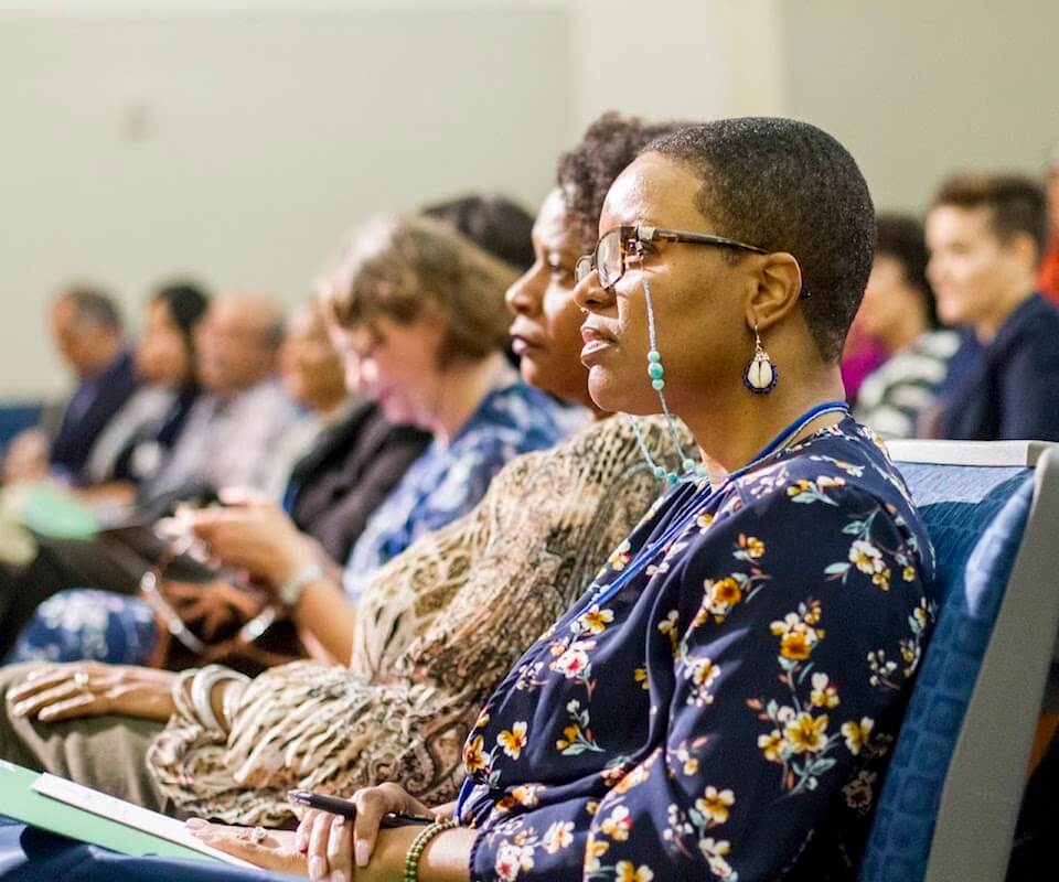 Faculty members listening to a presentation