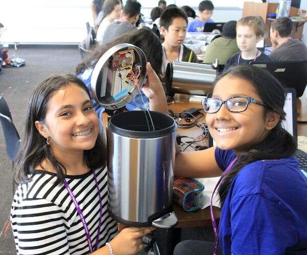 Two smiling students working on a project